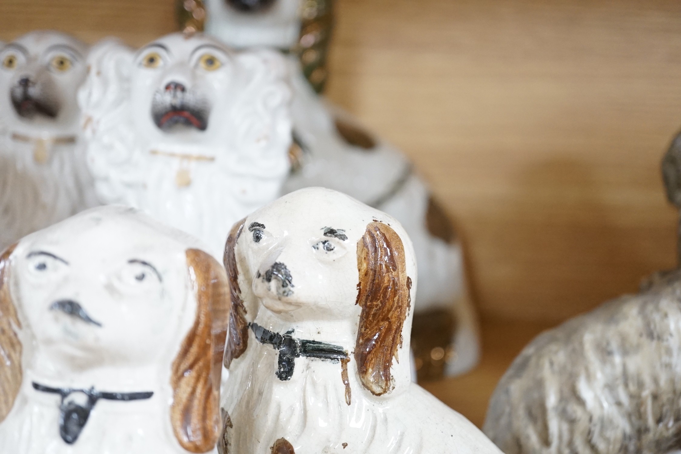 A mixed collection of mostly Staffordshire pottery models of recumbent dogs, hounds, etc. to include Dalmatians- 19.5cms high